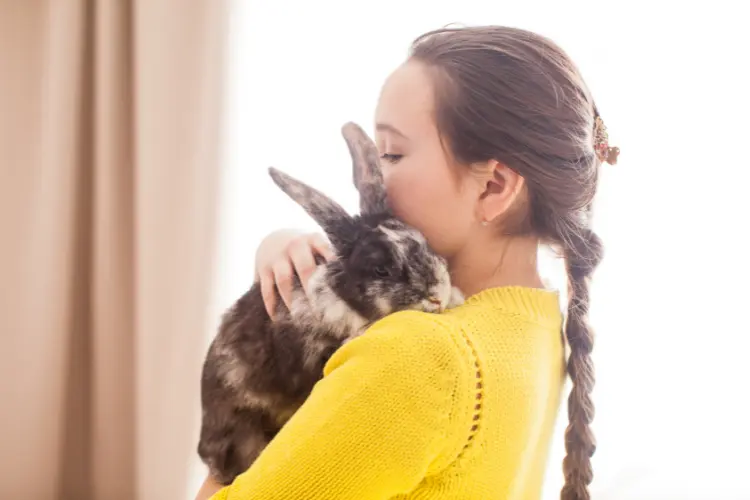 woman hugging her house pet rabbit
